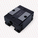 Black mechanical component on a light gray background with a subtle pattern